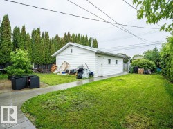 Detached garage with white siding, multiple windows, and a side door access - 