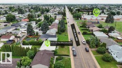 Aerial view of a residential neighborhood with detached single-family homes, mature landscaping, and an institutional building with a playground - 