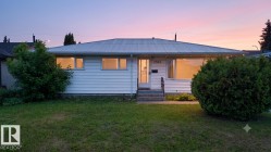 Single-story residence featuring white siding and a corrugated metal roof - 