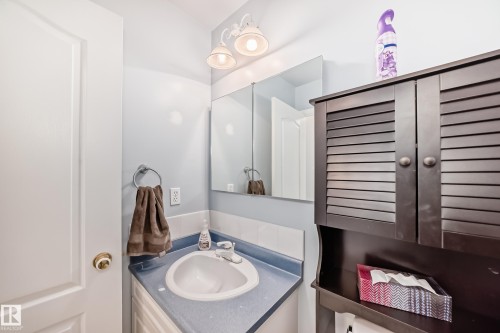 Bathroom vanity with an integrated sink, blue countertop, and chrome faucet - 7317 83 Avenue, Edmonton, AB 