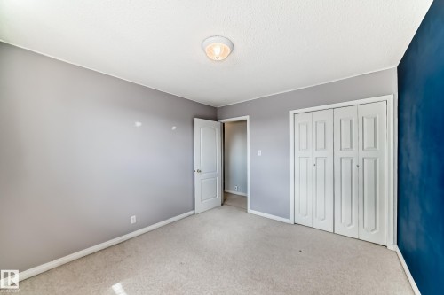 Neutral-toned carpeting and light gray walls create a versatile interior space - 7317 83 Avenue, Edmonton, AB 