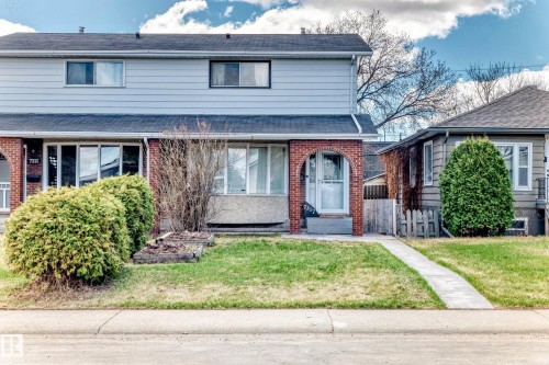 Two-story residential exterior featuring light-colored siding and a dark roof - 7317 83 Avenue, Edmonton, AB 