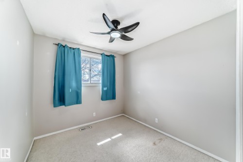 Room featuring neutral-toned walls, carpet flooring, and white trim - 7317 83 Avenue, Edmonton, AB 