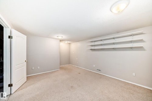 Spacious interior room featuring light-colored carpet flooring and neutral wall tones - 7317 83 Avenue, Edmonton, AB 