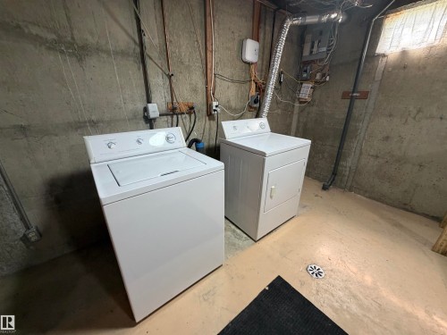 Dedicated laundry area featuring a top-load washing machine and a front-load dryer - 7317 83 Avenue, Edmonton, AB 