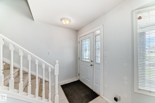 Entryway featuring a white door with decorative glass inserts and a sidelight - 7317 83 Avenue, Edmonton, AB 