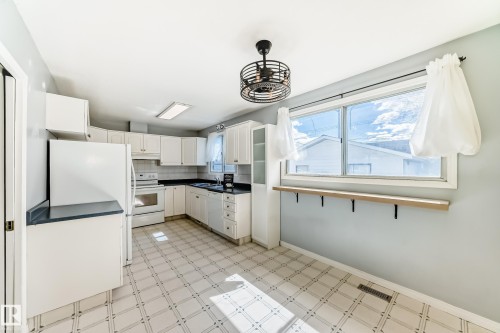 Bright kitchen featuring white cabinetry. - 7317 83 Avenue, Edmonton, AB 