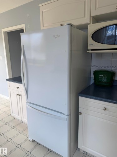 White bottom-freezer refrigerator positioned within cabinetry - 7317 83 Avenue, Edmonton, AB 