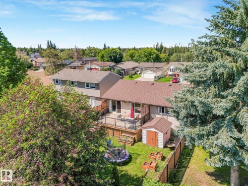 Backyard featuring a multi-level deck, fenced perimeter, and mature trees - 2035 49A Street, Edmonton, AB 