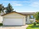 Light-colored siding exterior featuring an attached two-car garage with a white panel door - 2035 49A Street, Edmonton, AB 
