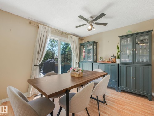 Dining area featuring wood-finish flooring and a patio door - 2035 49A Street, Edmonton, AB 