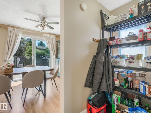 Dining area featuring wood-finish flooring, a ceiling fan with integrated lighting, and sliding glass doors leading to an outdoor space - 2035 49A Street, Edmonton, AB 