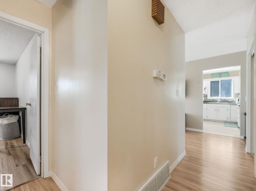 Hallway with light wood-finish flooring and neutral wall tones - 2035 49A Street, Edmonton, AB 