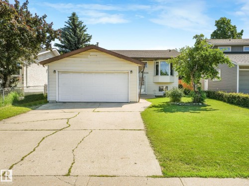 Exterior featuring a single-car garage, bay window, concrete driveway, and front lawn - 2035 49A Street, Edmonton, AB 