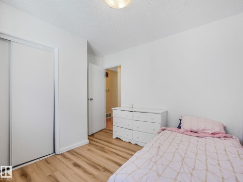 Bright room featuring wood-finish flooring, white walls, and a textured ceiling - 2035 49A Street, Edmonton, AB 