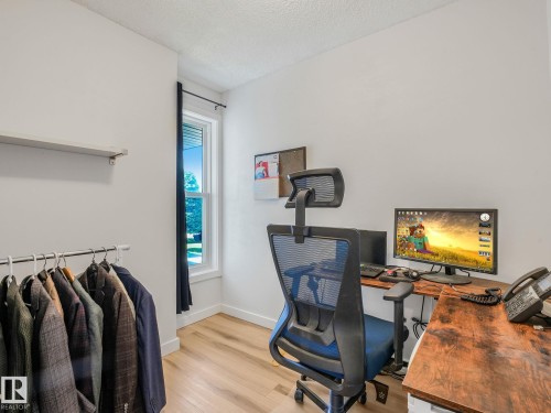 Bright room with light wood-finish flooring and a single window featuring dark curtain rods - 2035 49A Street, Edmonton, AB 