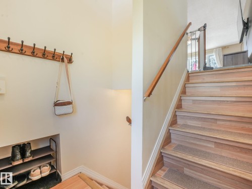 Wood-finish staircase with carpeted treads and a wood handrail - 2035 49A Street, Edmonton, AB 
