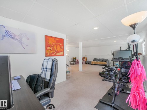 Spacious carpeted room featuring recessed lighting, white walls, and a dropped ceiling - 2035 49A Street, Edmonton, AB 
