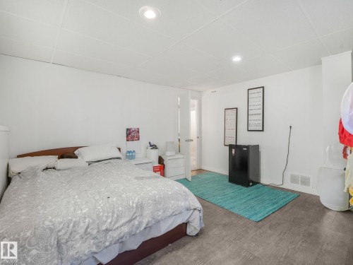 Room featuring wood-finish flooring, recessed lighting, and a white drop ceiling - 2035 49A Street, Edmonton, AB 