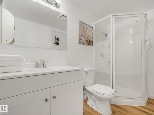 Compact bathroom featuring a white vanity with integrated sink, chrome faucet, and lower cabinetry - 2035 49A Street, Edmonton, AB 
