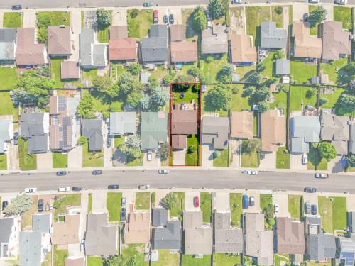 Expansive property featuring a sizable backyard with a verdant lawn and mature trees - 2035 49A Street, Edmonton, AB 