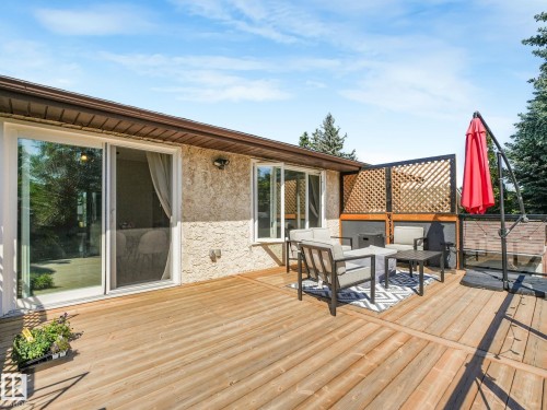 Expansive wood-finish deck with privacy lattice, offering direct access to the interior via sliding glass doors - 2035 49A Street, Edmonton, AB 