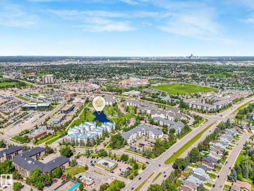Aerial perspective showcasing a residential area with a prominent cluster of multi-story buildings surrounding a central water feature - 2035 49A Street, Edmonton, AB 