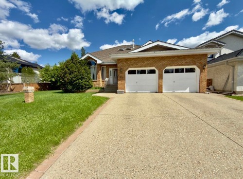 Brick facade residence featuring a two-car garage with white doors - 134 Wolf Ridge Place, Edmonton, AB 
