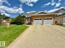 Brick facade residence featuring a two-car garage with white doors - 134 Wolf Ridge Place, Edmonton, AB 
