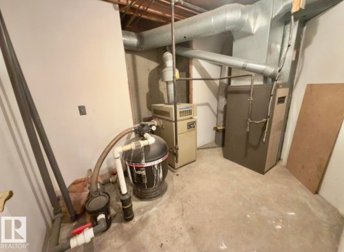 Utility space featuring a furnace, water heater, water filtration system, and exposed ductwork - 134 Wolf Ridge Place, Edmonton, AB 