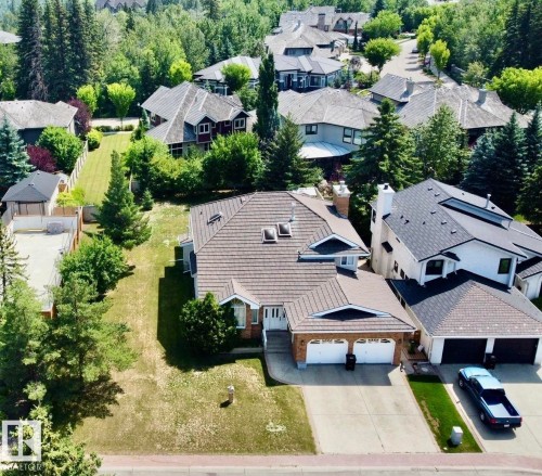 Two-story residence featuring a tile roof, brick facade, and an attached two-car garage - 134 Wolf Ridge Place, Edmonton, AB 