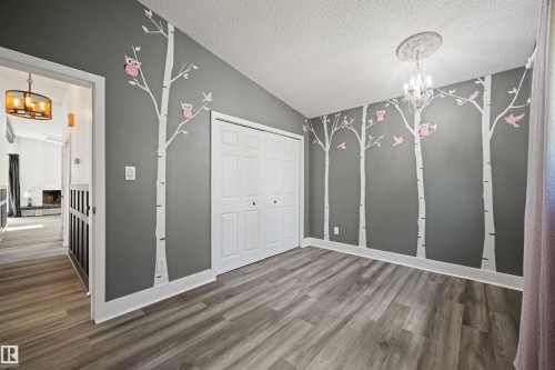 Room featuring wood-finish flooring, a vaulted ceiling, and painted accent walls - 28 Goodridge Drive, St. Albert, AB 