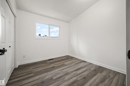 Bright room featuring wood-finish flooring, crisp white walls, and a double-pane window - 28 Goodridge Drive, St. Albert, AB 