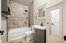 Bathroom featuring a white bathtub, toilet, and a vanity with an integrated sink - 