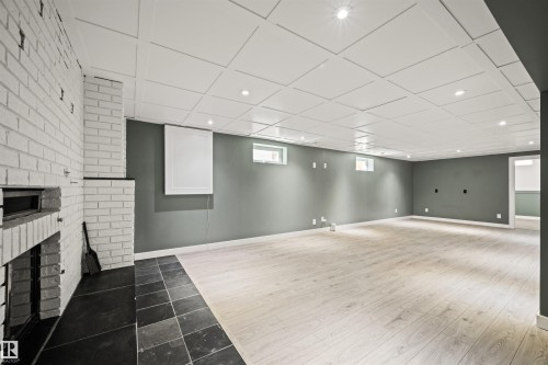 Spacious room featuring light wood-finish flooring, recessed lighting, and a white coffered ceiling - 28 Goodridge Drive, St. Albert, AB 