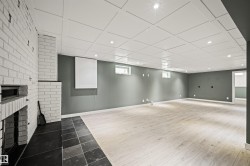 Spacious room featuring light wood-finish flooring, recessed lighting, and a white coffered ceiling - 