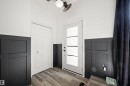 Entryway featuring board and batten wainscoting, wood-finish flooring, and a white paneled door with frosted glass inserts - 28 Goodridge Drive, St. Albert, AB 