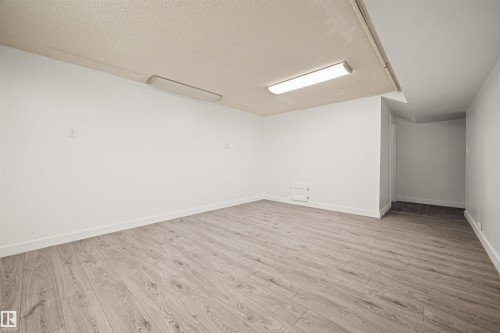 Spacious room featuring wood-finish flooring, white walls, and bright overhead lighting - 28 Goodridge Drive, St. Albert, AB 