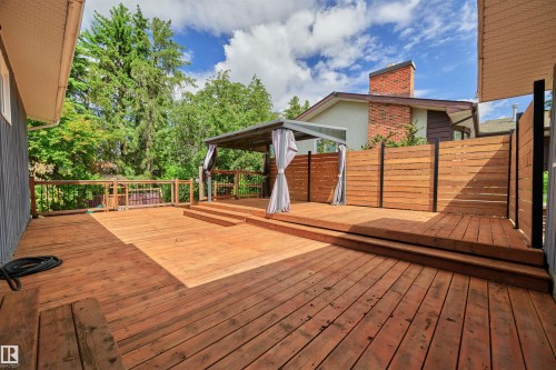 Multi-level wood deck featuring a covered gazebo, integrated privacy screening, and wood railings - 28 Goodridge Drive, St. Albert, AB 