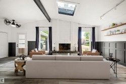 Vaulted ceiling with exposed beam, white brick fireplace with dark tile hearth, and wood-finish flooring - 