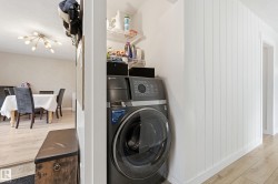 Dedicated laundry area featuring a stacked washer and dryer unit - 