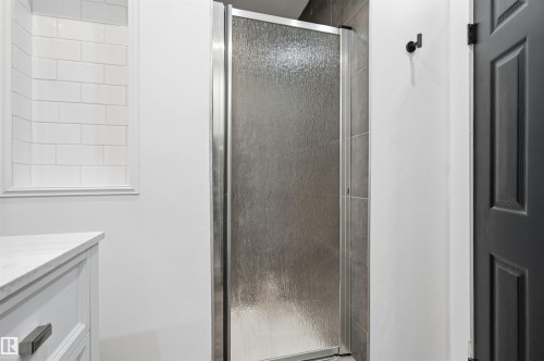 Frosted glass shower enclosure with chrome hardware - 12326 92 Street, Edmonton, AB - Indoor Photo Showing Bathroom