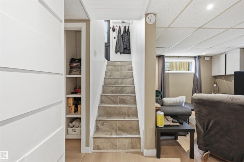 Staircase featuring tile treads, leading to an upper level with light wood-finish flooring - 12326 92 Street, Edmonton, AB - Indoor Photo Showing Other Room