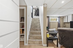Staircase featuring tile treads, leading to an upper level with light wood-finish flooring - 