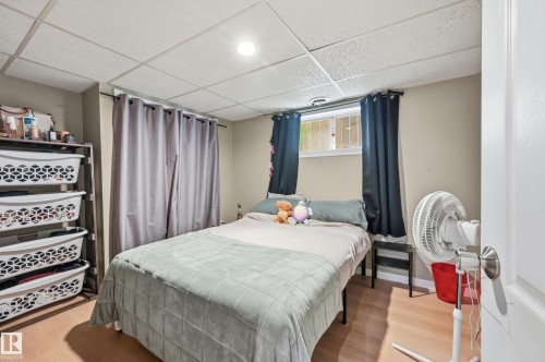 Light wood-finish flooring complements the neutral wall tones - 12326 92 Street, Edmonton, AB - Indoor Photo Showing Bedroom