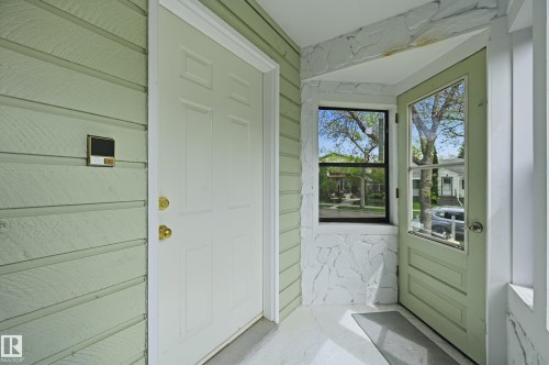 Entryway featuring light green siding, a white front door with brass hardware, and a storm door - 12326 92 Street, Edmonton, AB -  Photo Showing Other Room