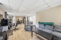 Finished lower-level space featuring light wood-finish flooring, recessed lighting, and a drop ceiling - 