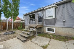 Gray siding exterior with a bay window and a rectangular basement window - 