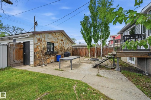 Detached garage with stone cladding and a side entry, complemented by a concrete patio - 12326 92 Street, Edmonton, AB - Outdoor