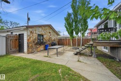 Detached garage with stone cladding and a side entry, complemented by a concrete patio - 